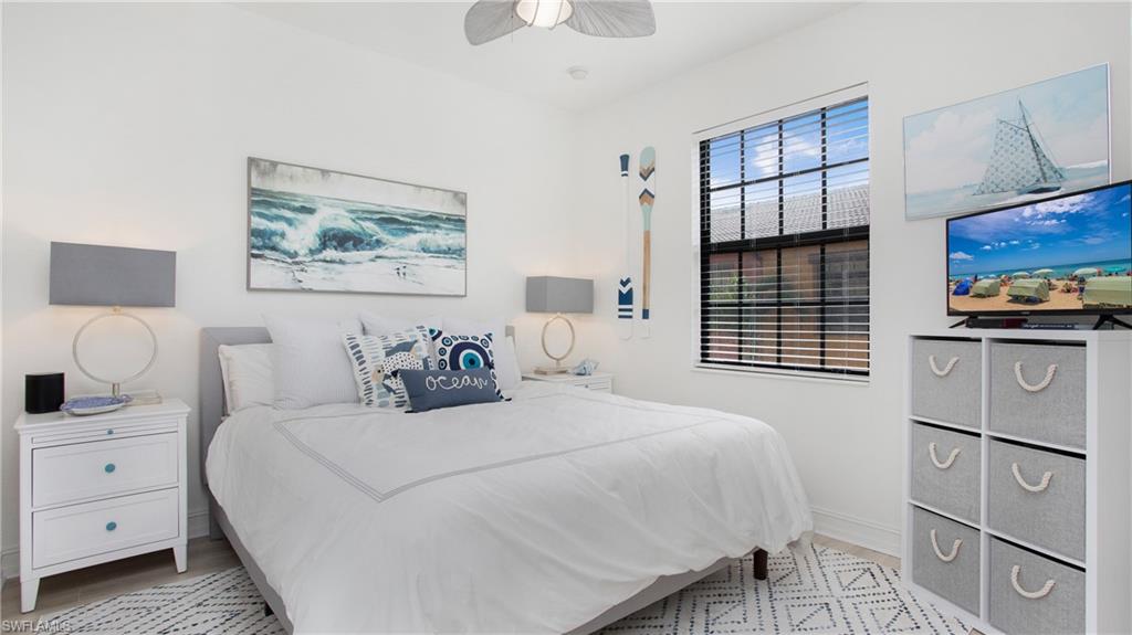 9078 Albion Lane South, Unit 6603 Naples, FL 34113 - Photo 20 of 41 a bedroom with a bed and a chandelier