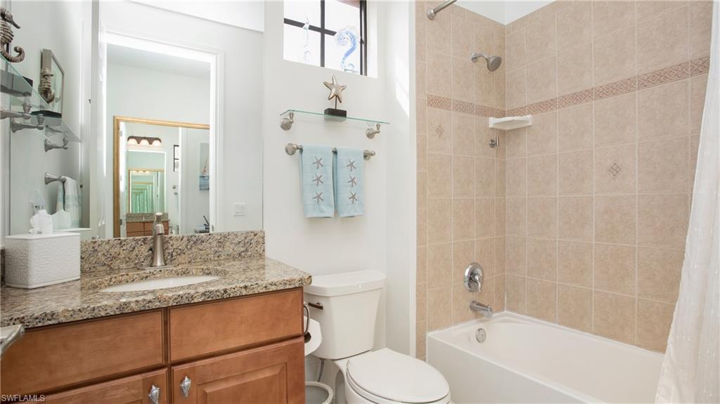 9078 Albion Lane South, Unit 6603 Naples, FL 34113 - Photo 21 of 41 a bathroom with a granite countertop sink toilet mirror and bathtub