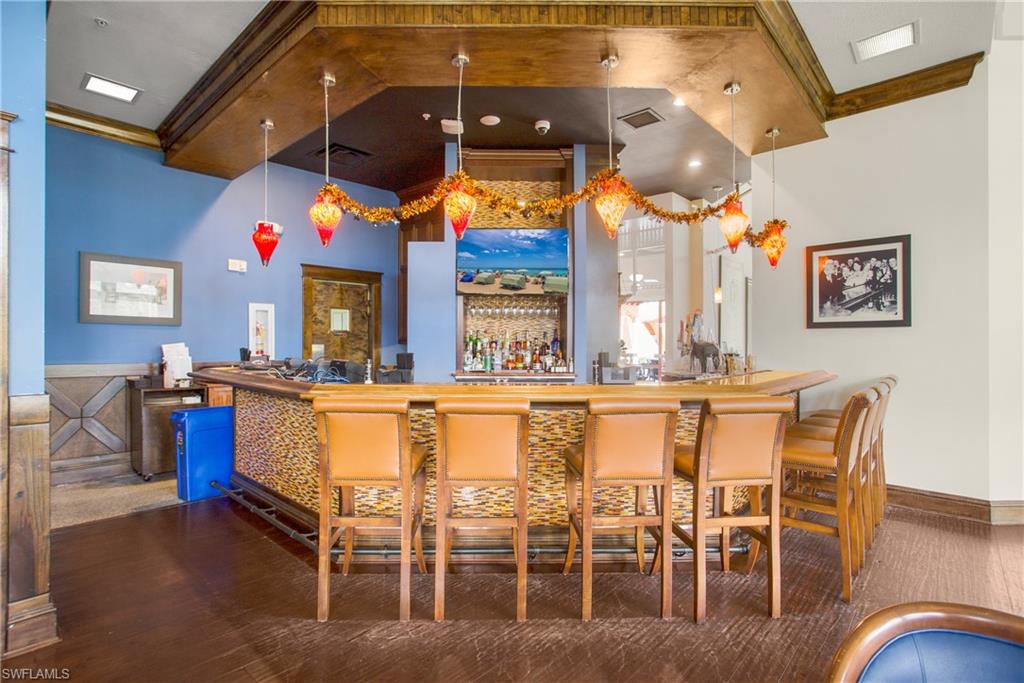 9078 Albion Lane South, Unit 6603 Naples, FL 34113 - Photo 35 of 41 a kitchen with stainless steel appliances kitchen island granite countertop a table and chairs in it