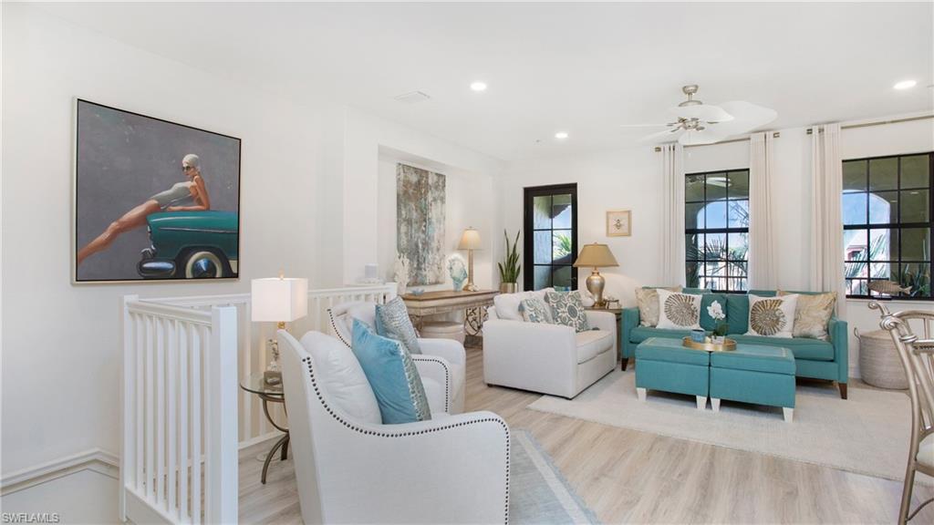 9078 Albion Lane South, Unit 6603 Naples, FL 34113 - Photo 6 of 41 a living room with furniture and a chandelier