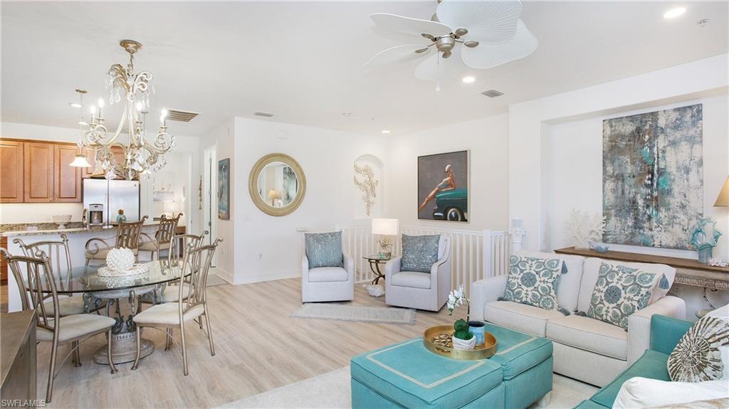 9078 Albion Lane South, Unit 6603 Naples, FL 34113 - Photo 8 of 41 a living room with furniture a clock and a chandelier