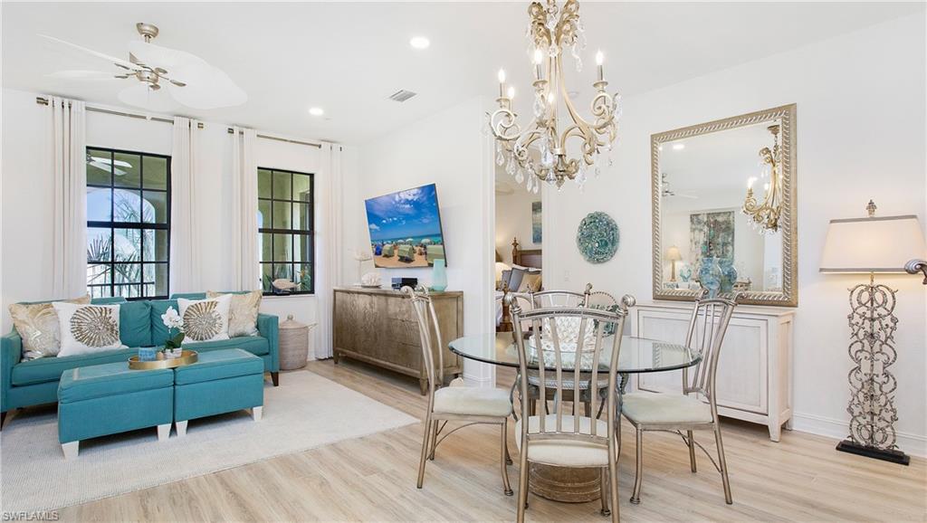 9078 Albion Lane South, Unit 6603 Naples, FL 34113 - Photo 9 of 41 a living room with furniture and a chandelier
