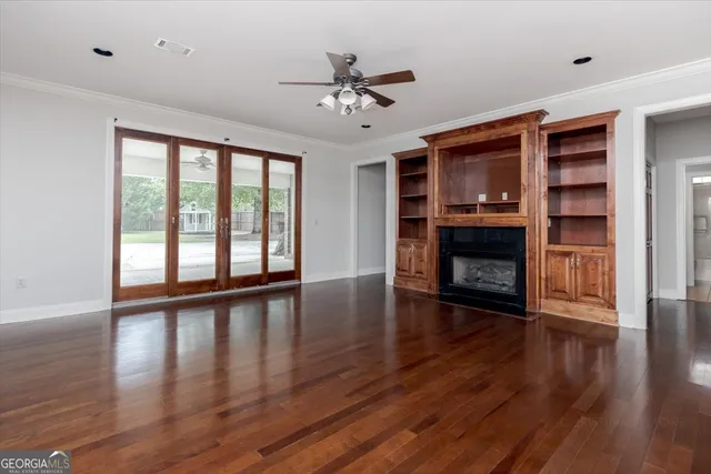 an empty room with windows and ceiling fan view