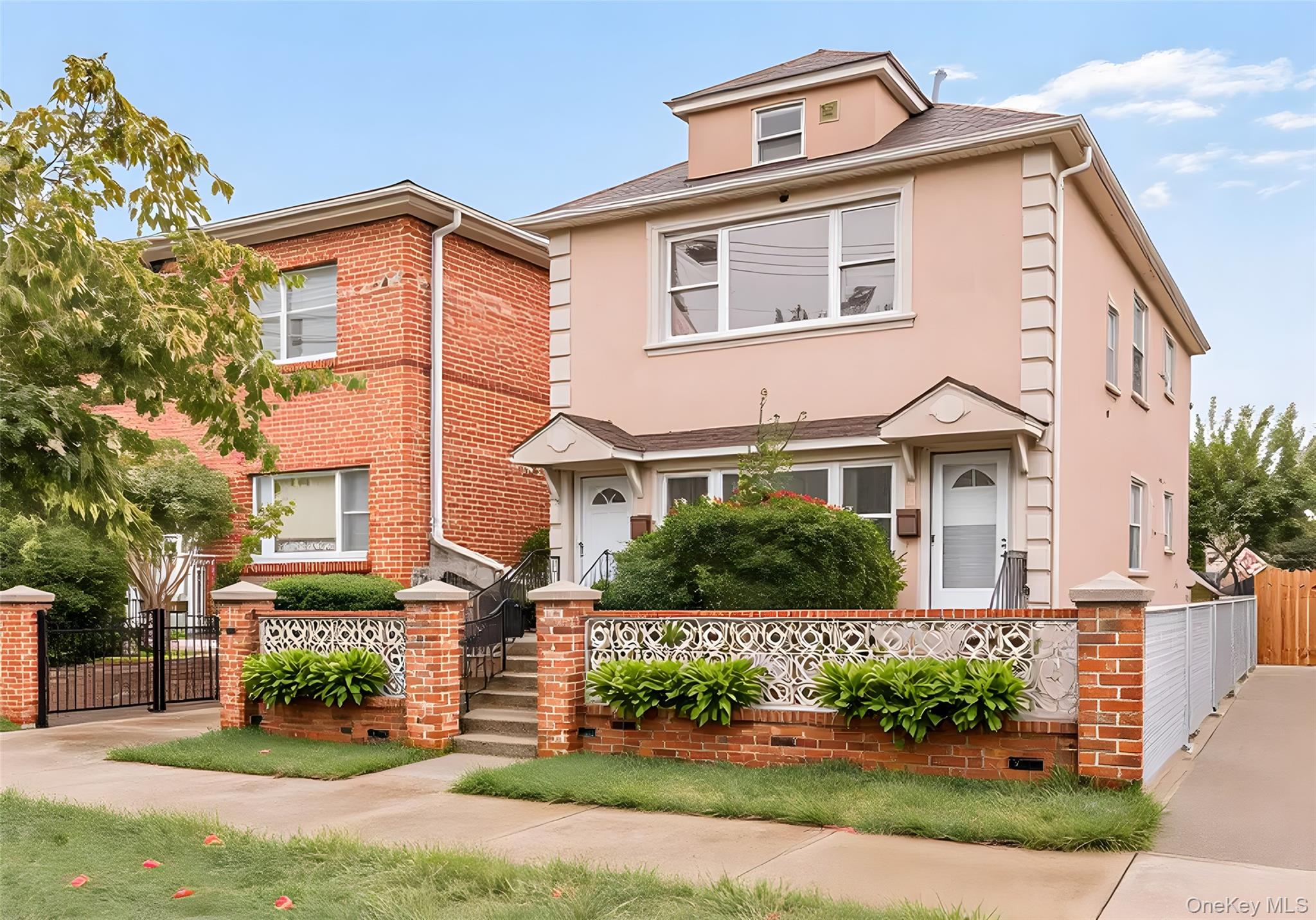 1616 Library Avenue Bronx, NY 10465 - Photo 1 of 20 View of front of house featuring a fenced front yard, brick siding, a gate, and stucco siding
