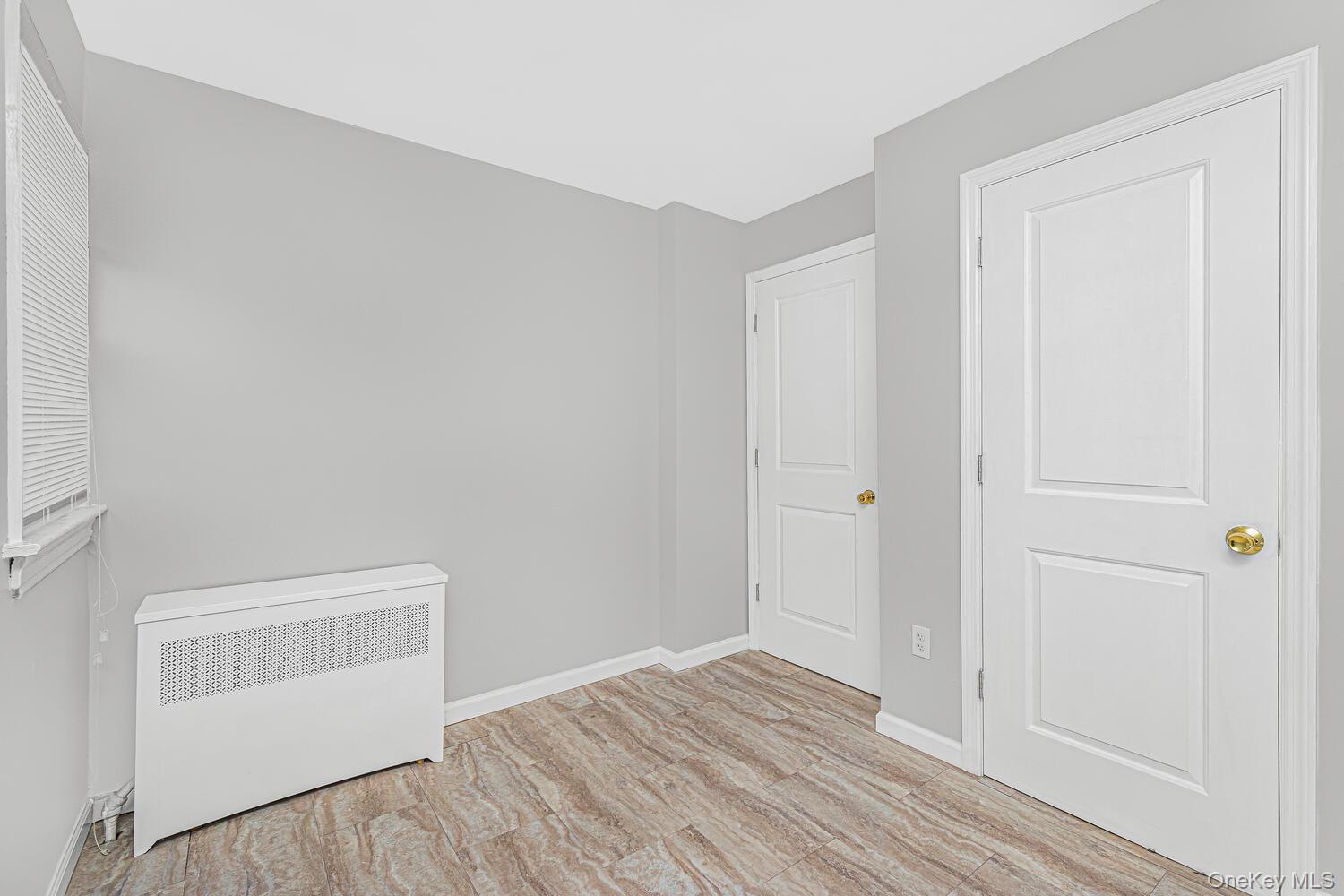 1616 Library Avenue Bronx, NY 10465 - Photo 8 of 20 Unfurnished bedroom with radiator heating unit and light wood-style floors