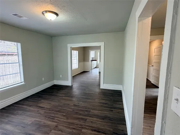an empty room with wooden floor and a window