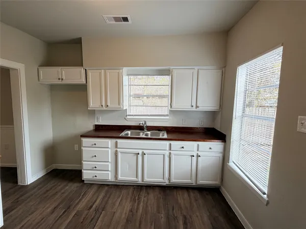 a kitchen with stainless steel appliances a sink cabinets and wooden floor
