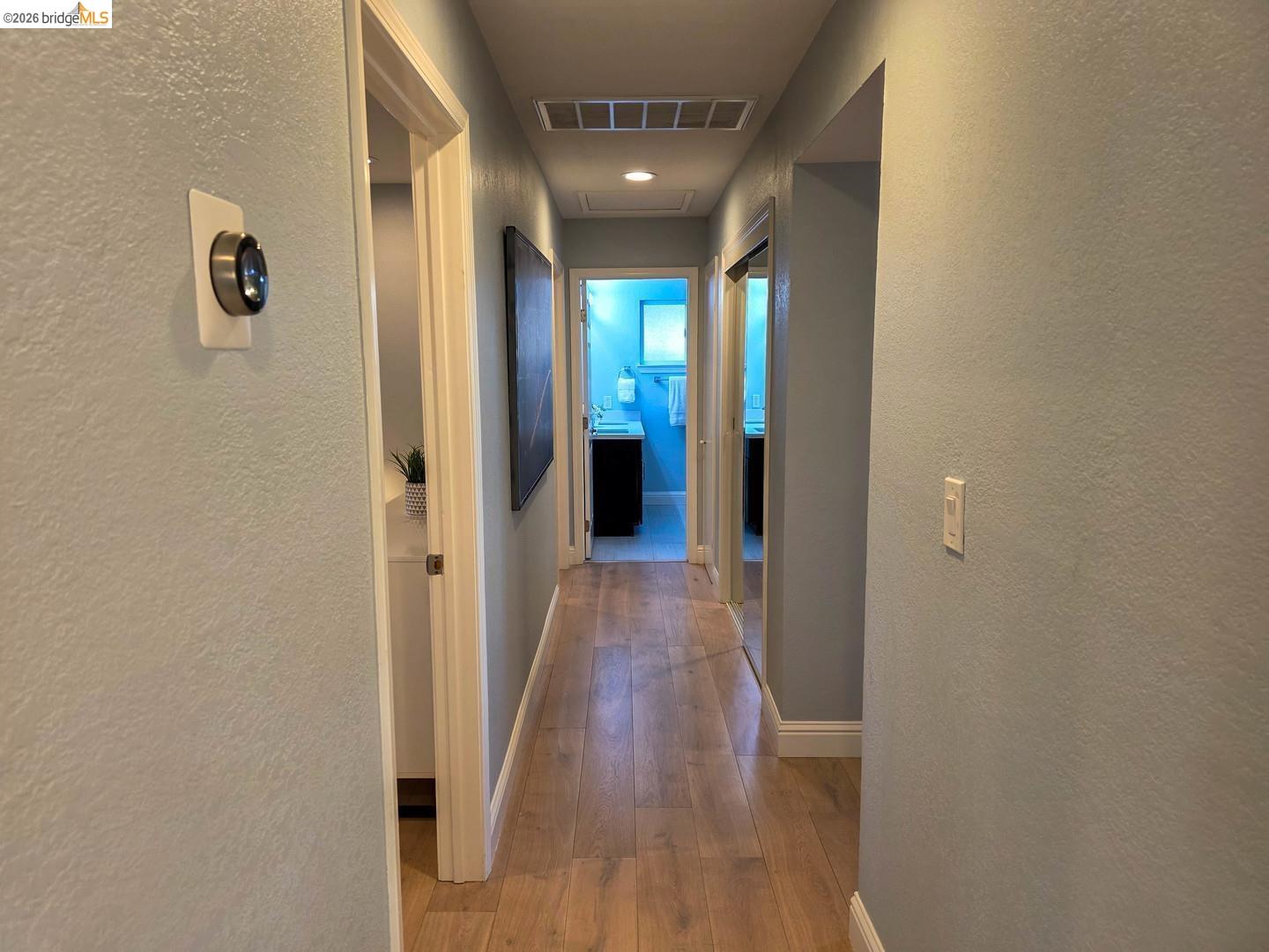 965 Springer Road Los Altos, CA 94024 - Photo 23 of 31 Hallway featuring light wood-finish flooring, light blue walls, and white baseboards
