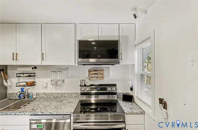 a kitchen with stainless steel appliances a stove a sink a refrigerator and a refrigerator