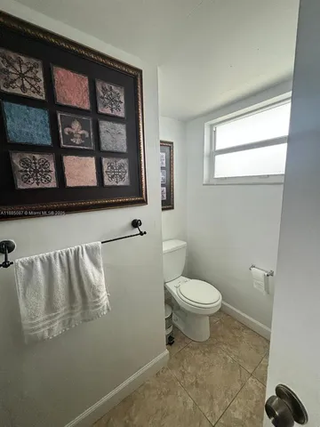 a living room with couches a fireplace and a dining table with a large window