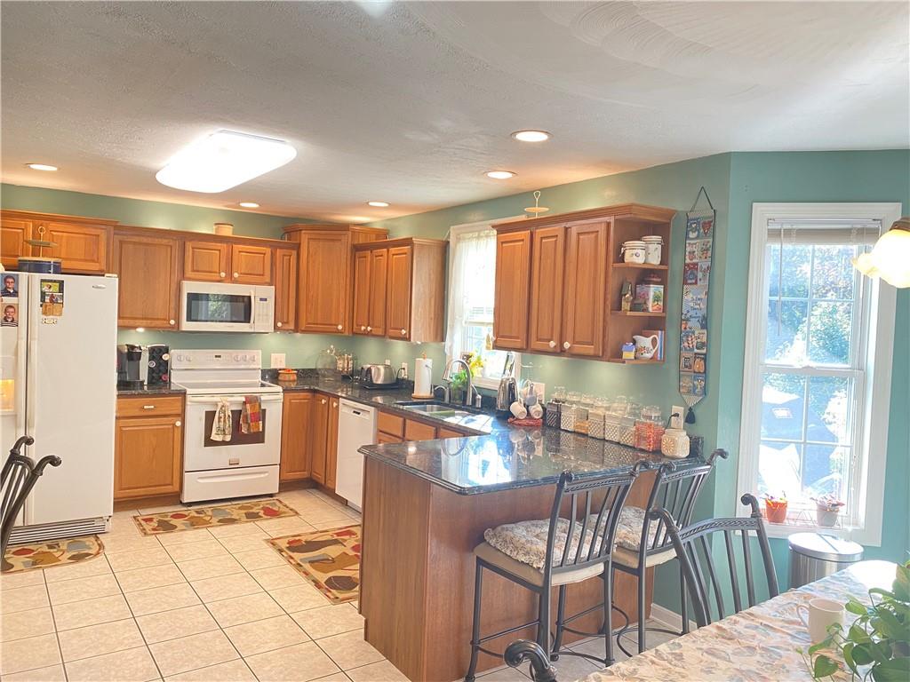 5 Short Road Washington, PA 15301 - Photo 4 of 20 a kitchen with stainless steel appliances granite countertop a stove top oven a sink dishwasher a dining table and chairs with wooden floor