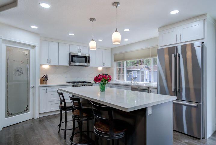 37105 Sapphire Road Burney, CA 96013 - Photo 12 of 39 a kitchen with stainless steel appliances granite countertop a table chairs refrigerator and microwave