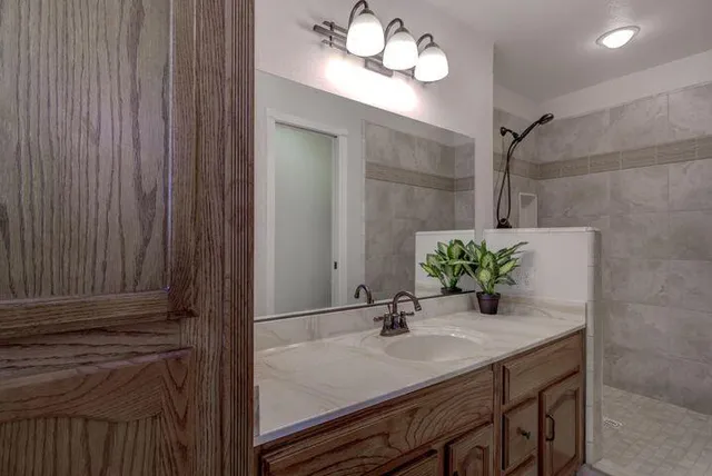 a bathroom with a granite countertop sink and a mirror