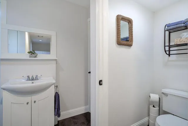 a bathroom with a toilet sink and mirror
