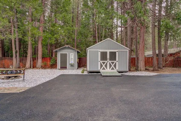 a view of a house with a yard and large trees
