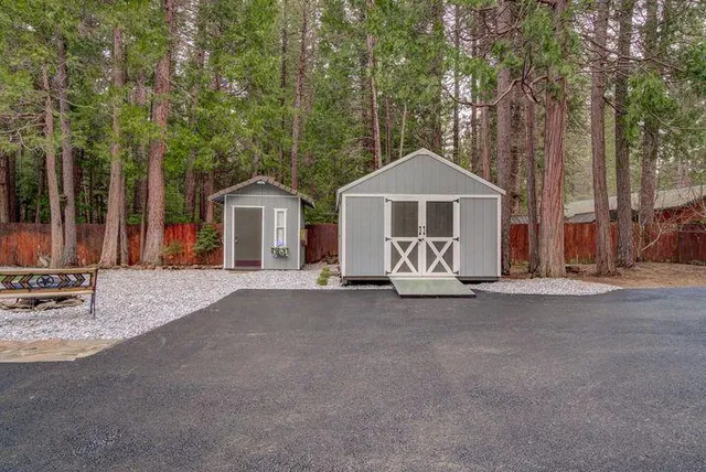 a view of a house with a yard and large trees