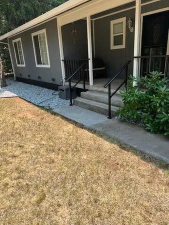 a view of backyard with a chair and potted plants