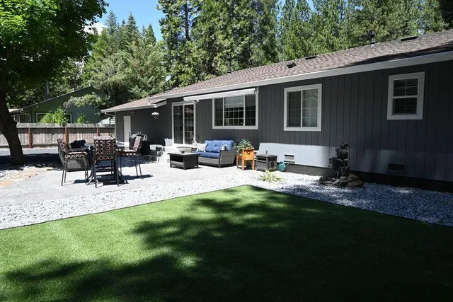 a view of backyard of house with outdoor seating and green space