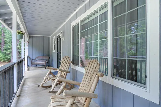 a view of balcony with two chairs and a large window