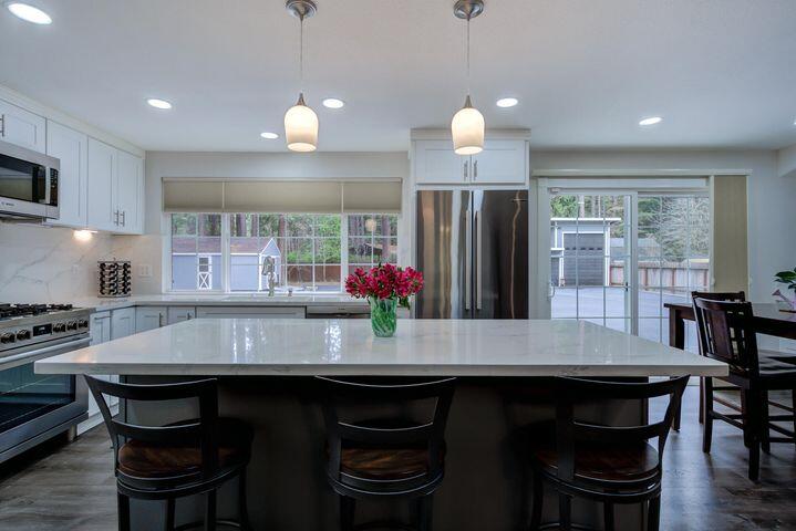 37105 Sapphire Road Burney, CA 96013 - Photo 10 of 39 a kitchen with granite countertop a table chairs stove refrigerator and microwave