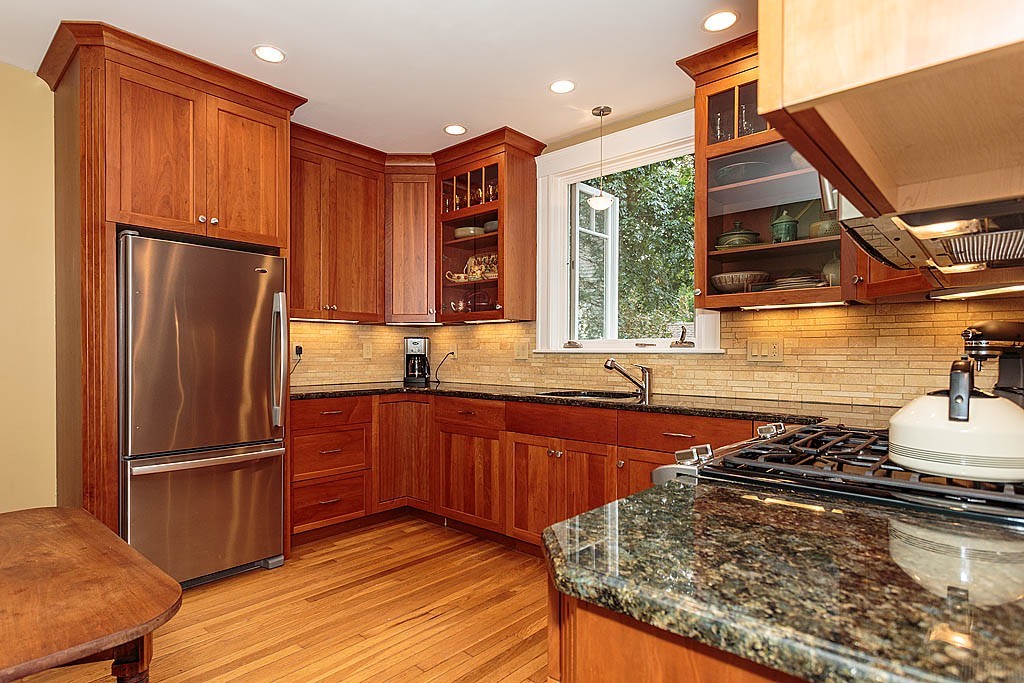 306 Appleton Street Arlington, MA 02476 - Photo 10 of 24 a kitchen with stainless steel appliances granite countertop a refrigerator a sink dishwasher a stove and a dining table with wooden floor