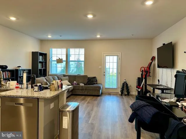 a living room with furniture flat screen tv and a large window