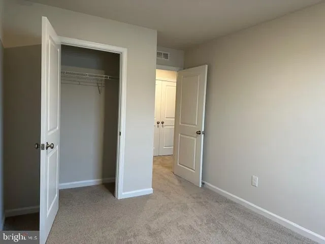 an empty room with closet and a bathroom