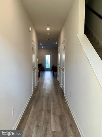 a view of a hallway with wooden floor
