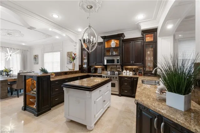 a large kitchen with granite countertop a sink a stove and a wooden floors