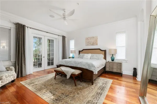 a bedroom with a bed and large windows