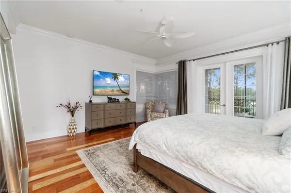 a spacious bedroom with a bed and wooden floor