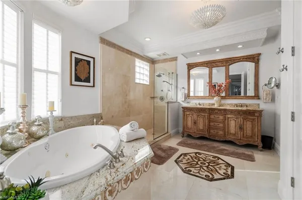 a spacious bathroom with a tub a sink and mirror