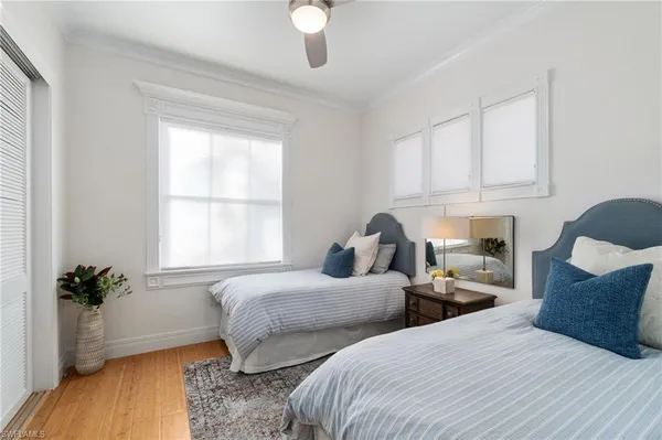 a bedroom with two beds and a potted plant