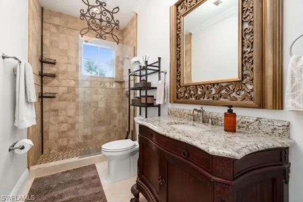 a bathroom with a granite countertop sink a toilet and shower