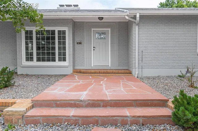 a view of a house with backyard and a tree