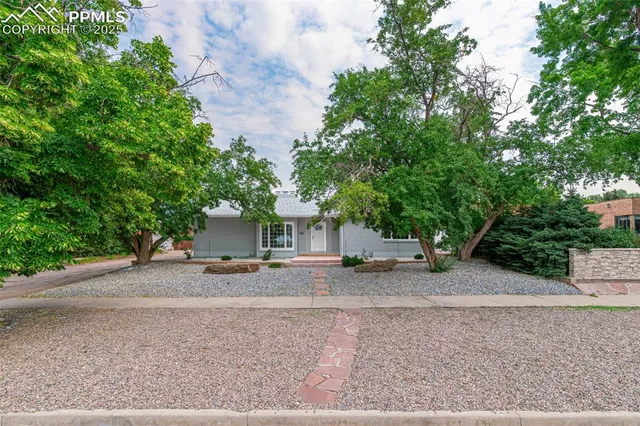 a front view of a house with a garden and yard