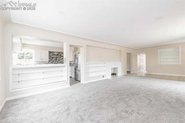 an empty room with windows and bathroom