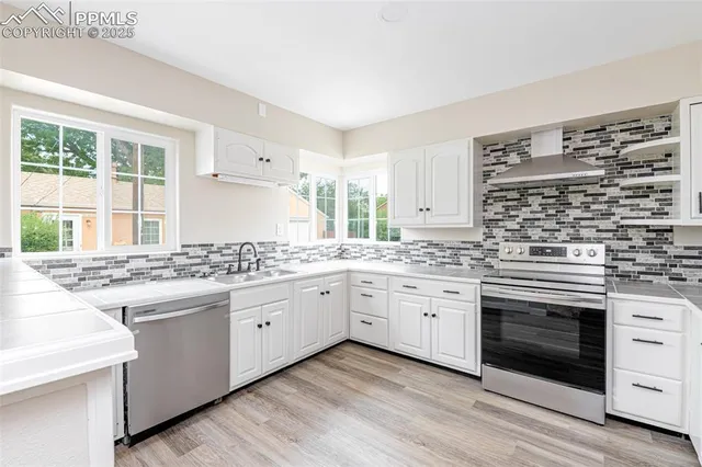 a kitchen with a refrigerator sink and cabinets