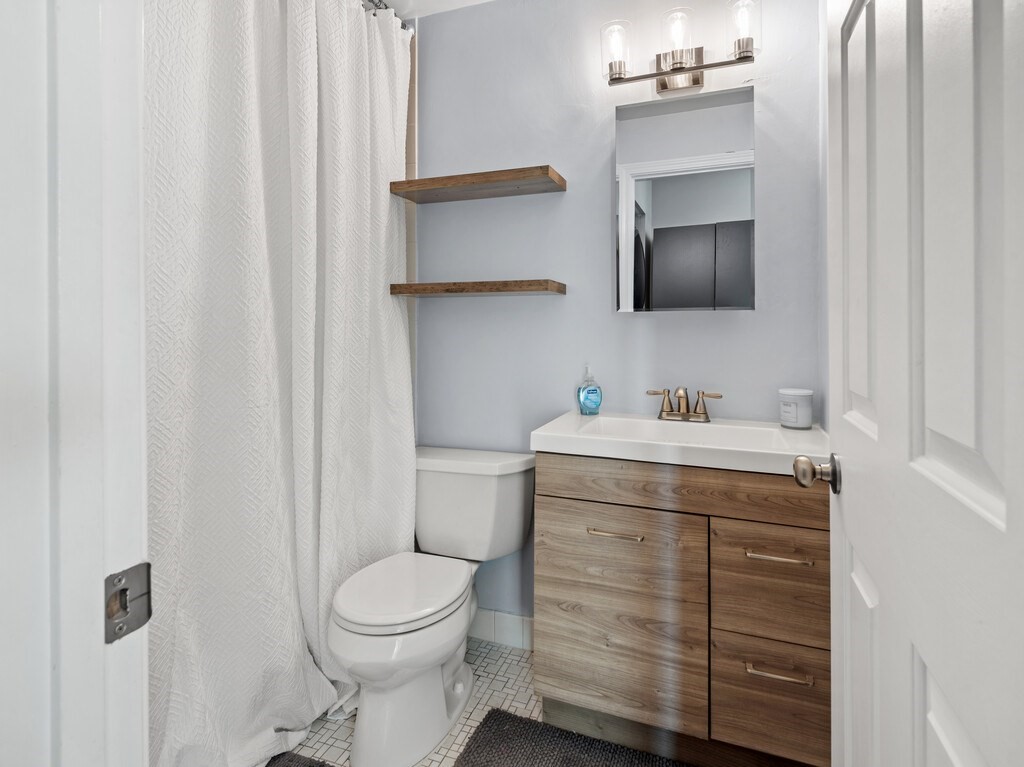 10 Linwood Street, Unit 214 Malden, MA 02148 - Photo 14 of 37 a bathroom with a toilet sink and mirror