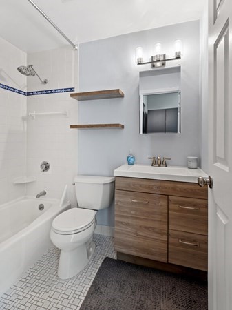10 Linwood Street, Unit 214 Malden, MA 02148 - Photo 16 of 37 a bathroom with a sink toilet a mirror a bathtub and shower