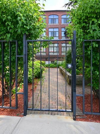 10 Linwood Street, Unit 214 Malden, MA 02148 - Photo 33 of 37 a view of a brick building next to a yard