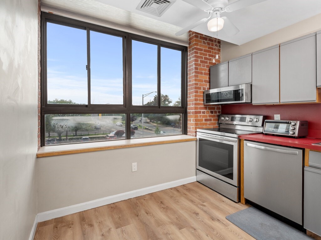 10 Linwood Street, Unit 214 Malden, MA 02148 - Photo 5 of 37 a kitchen with granite countertop a stove and a wooden floors