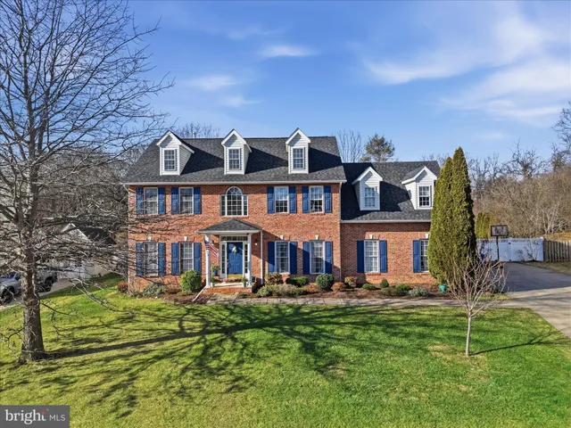 a front view of a building with a garden and plants