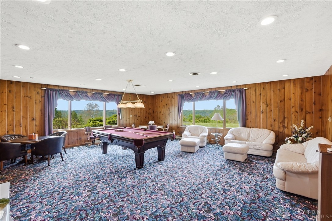5669 O Neall Road Waynesville, OH 45068 - Photo 30 of 72 This entertainment room features extensive wood paneling and large windows, offering expansive views of the natural landscape.