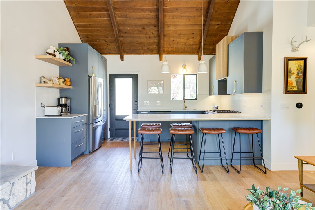 1032 Grass Valley Road Lake Arrowhead, CA 92352 - Photo 11 of 48 a living room with stainless steel appliances kitchen island granite countertop a table chairs and a wooden cabinets