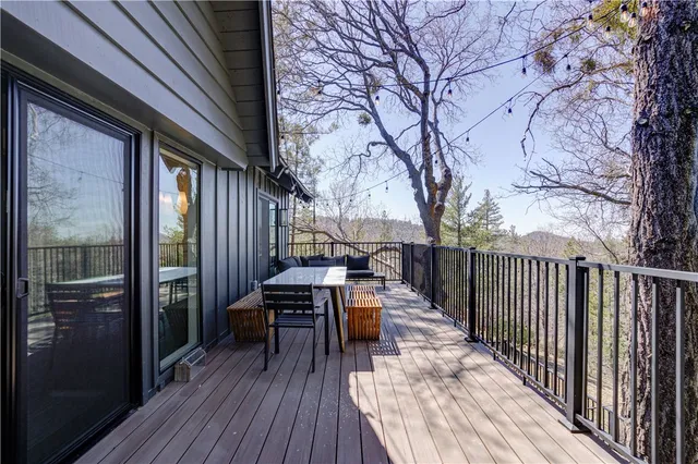 a view of a patio with table and chairs with wooden floor and fence