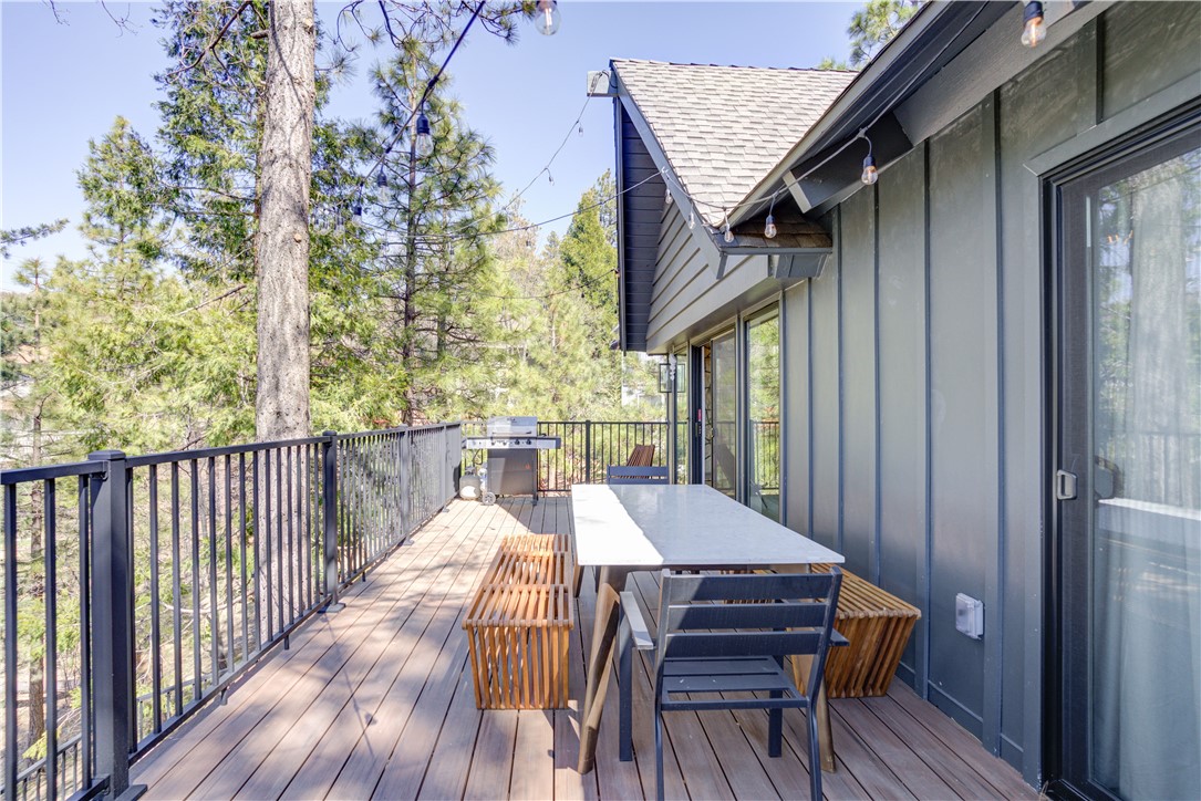 1032 Grass Valley Road Lake Arrowhead, CA 92352 - Photo 24 of 48 a view of a patio with table and chairs with wooden floor and fence