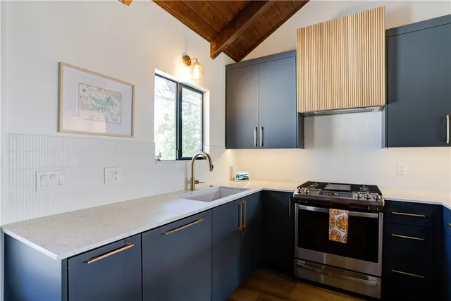 a kitchen with a sink a stove and cabinets