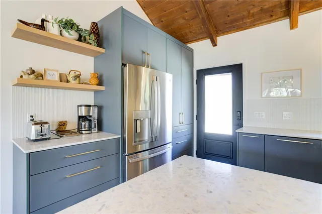 a kitchen with stainless steel appliances a stove a sink dishwasher and a refrigerator with wooden floor