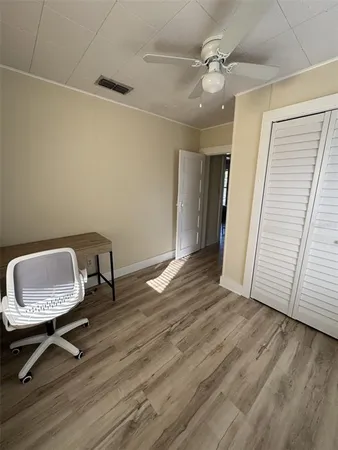 a view of a room with wooden floor and a ceiling fan